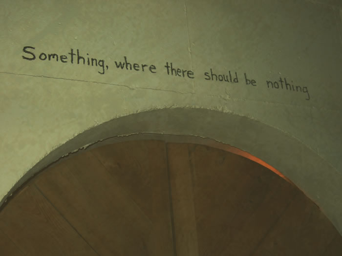 Sign on the wall reads...Something, where there should be nothing 